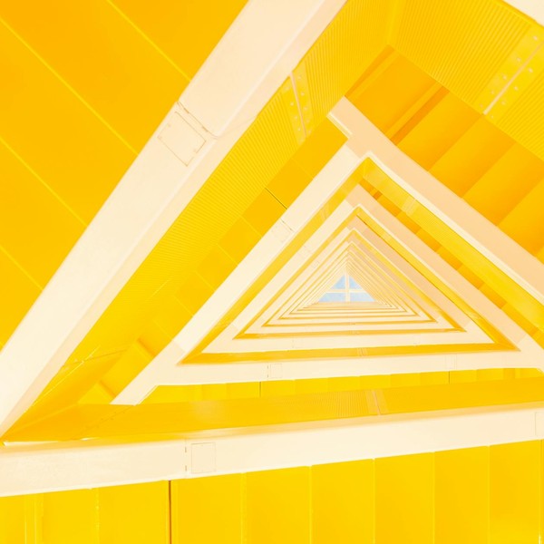 A modern abstract view of a yellow staircase with geometric lines and shapes.